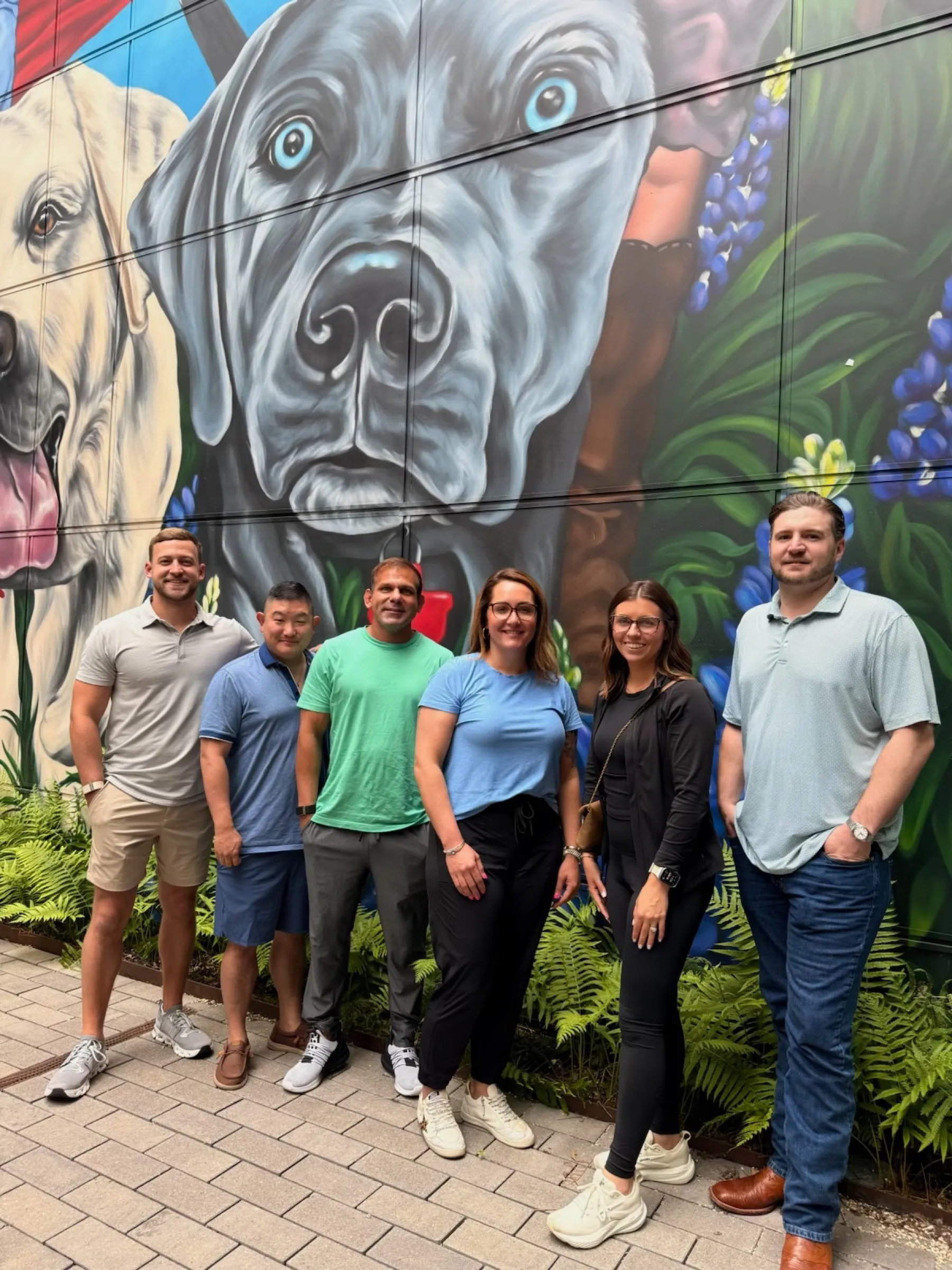 Matthew Henry with the Shop Talk crew in front of a painted mural